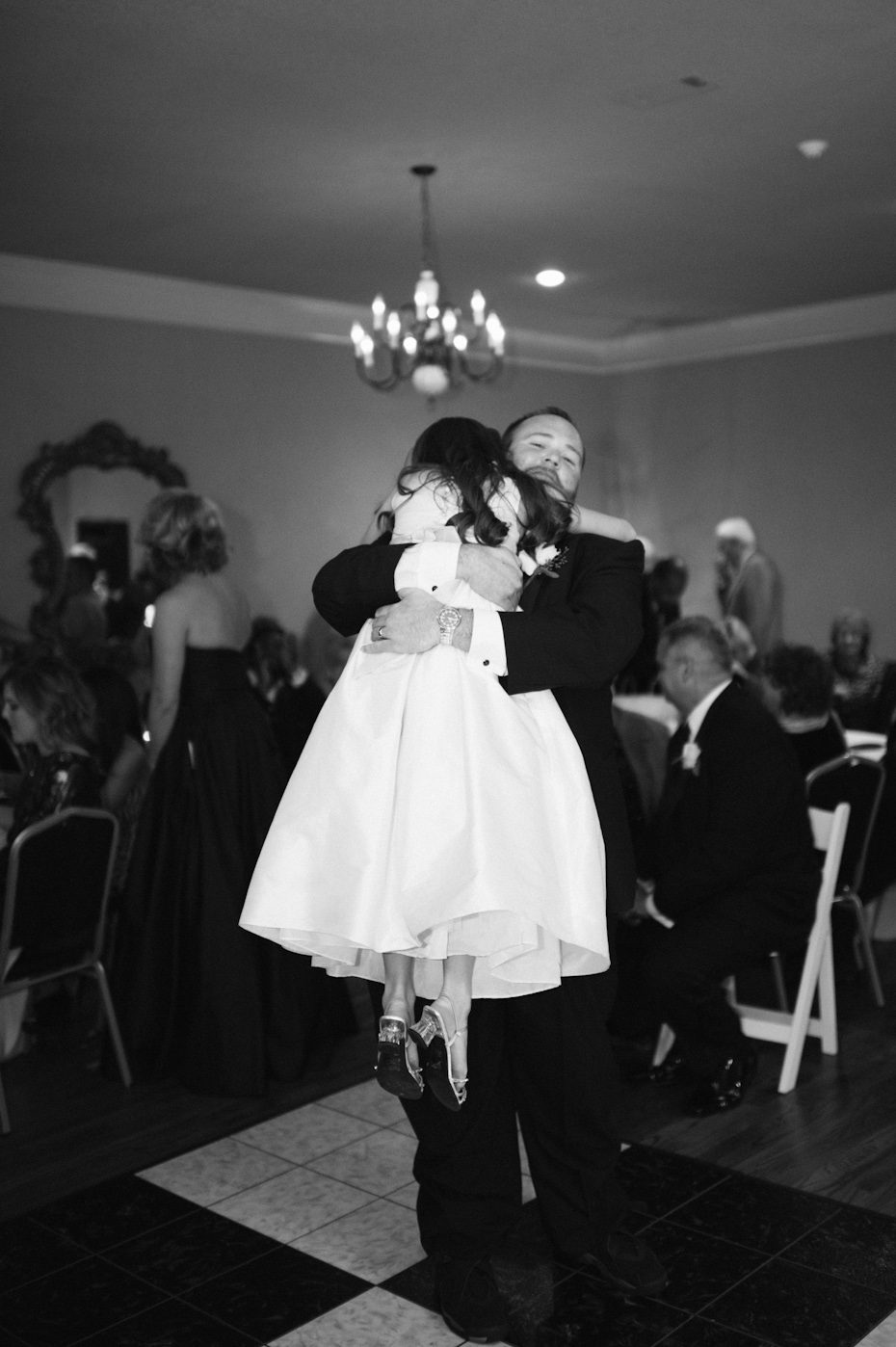 Groom and flower girl hug