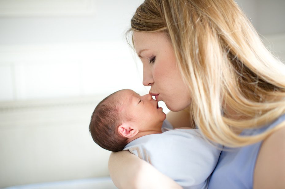 Mom kissing newborn